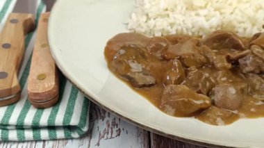 Soslu sığır böbreği ve tabakta pilav.