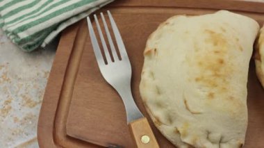 Calzone pizza, üst manzara, kesme tahtasında.