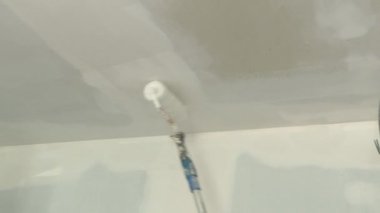 Tavanda yuvarlanan beyaz boya.