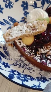 Bir dilim yaban mersinli turta ve bir kepçe mangolu dondurma.