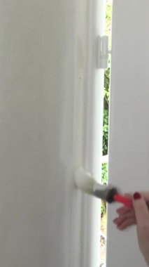 bir evin iç duvarını boyayan kişi