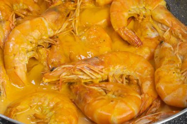 Köri ve hindistan cevizi sütüyle pişirilmiş karides, yakın plan.