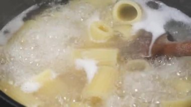 Rigatoni makarnası, yakın çekim, kaynar suda pişirme.