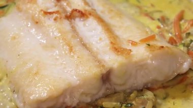 Krema sosunda kaynamış beyaz balık filetosu.