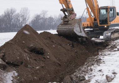 İnşaat alanında inşaat mühendisliği yapan bir kazıcı ile toprak çalışmaları
