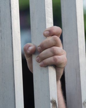 Hapishane hücresinin penceresinden dışarı bakan mahkum.