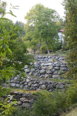 Bahçenin etrafındaki taş duvar kamusal alandan çizilmiş.