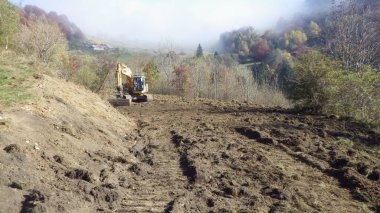 İnşaat alanında kazıcı, toprak işçiliği ve inşaat projesi için ağır makineler.