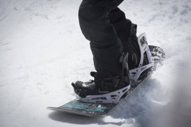 Kışın karlı bir dağda snowboardcu.