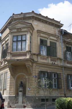 Eski bir apartman dairesinde ya da şehirde bir dairede yaşıyor.