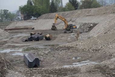 İnşaat alanında kazıcı, toprak işçiliği ve inşaat projesi için ağır makineler.