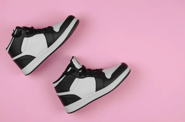 黑色和白色运动鞋粉红的背景 顶部视图 为鞋店做广告时用的时髦新运动鞋 — 图库照片