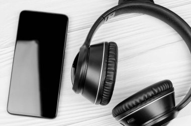 Kablosuz kulaklık ve ahşap arka planda akıllı telefon. Spor ve müzik