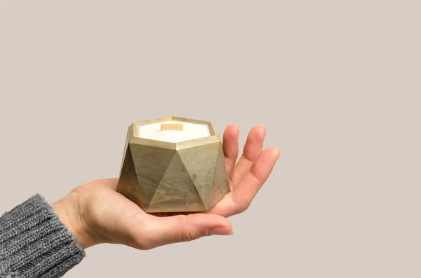 stock image A woman's hand holds a decorative candle in a golden pot