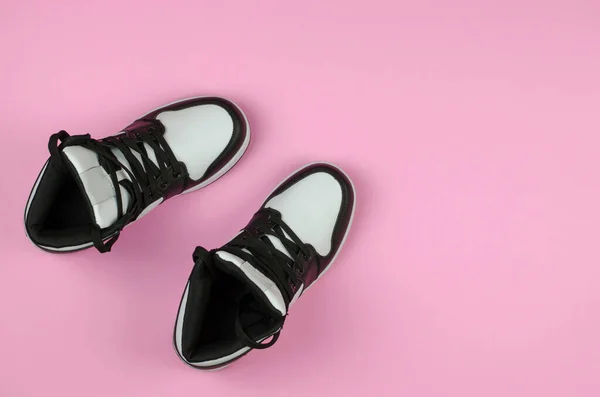 为鞋店做广告用的时髦的新运动鞋 黑色和白色运动鞋粉红的背景 顶部视图 — 图库照片
