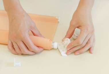 Paten panjurları montajı. Kadınların elleri tekerlekli jaluzi yapıyor.