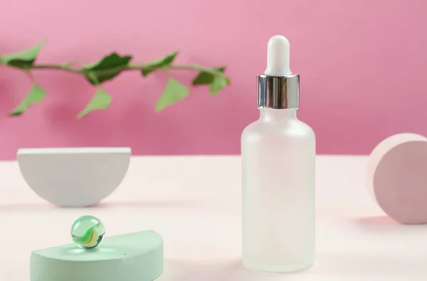 White cosmetic bottle and flowers. Bottle of cosmetic serum or essential oil