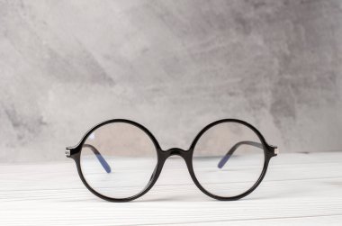 Masanın üzerinde siyah yuvarlak çerçeveli görsellik için şık gözlükler.