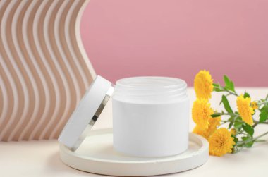 Yuvarlak bir büfede açık beyaz bir krema kavanozu. Kozmetik reklam modeli