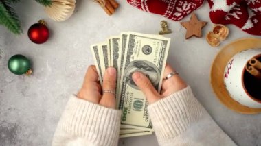 Amerikan Doları 'nı sayan kız. Manzaralı Kız Noel hediyelerini sayıyor. Kadın eli bütçe yapıyor, alışveriş çılgınlığı için para dengesini hesaplıyor. Kadın muhasebeci vergi ödüyor.. 