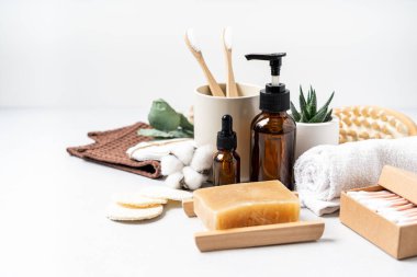 Doğal banyo ve spa aletleri. Sıfır sürdürülebilir yaşam tarzı konsepti. Bambu diş fırçası, doğal sabun, pamuk pedler, beyaz arka planda yeniden kullanılabilir şişelerde ev yapımı DIY güzellik ürünleri..