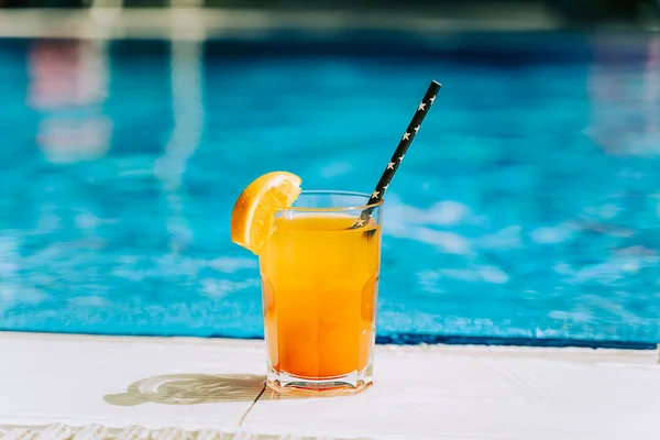 탄산가스 수영장 오렌지 레모네이드 칵테일이 사이드 근처에 있습니다 수영장에서 마시고 스톡 사진