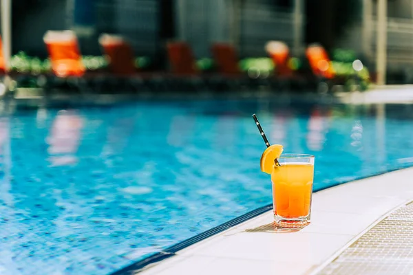 탄산가스 수영장 오렌지 레모네이드 칵테일이 사이드 근처에 있습니다 수영장에서 마시고 로열티 프리 스톡 사진