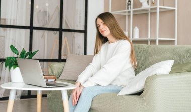 Çevrimiçi eğitim ve çalışma mesafesi. Not defterli bir iş kadını. Ev ofisinde dizüstü bilgisayarlı serbest çalışan bir kız. Bilgisayarları ve online dükkanları kullanarak. Eline odaklan.