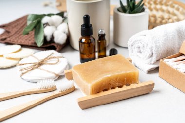Doğal banyo ve spa aletleri. Sıfır sürdürülebilir yaşam tarzı konsepti. Bambu diş fırçası, doğal sabun, pamuk pedler, beyaz arka planda yeniden kullanılabilir şişelerde ev yapımı DIY güzellik ürünleri..