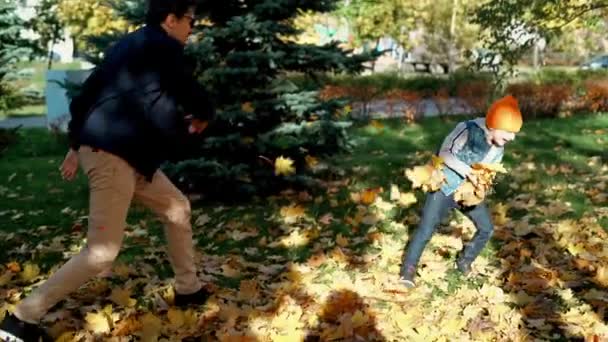 Батько Син Розважаються Осінньому Парку Опалим Листям Викидаючи Лист Дитячий — стокове відео