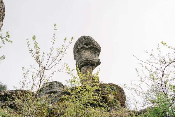 山の崖の上に立っているヘッド形の岩のボルダー ロッキー バロウの端に吊るされた石 — ストック写真