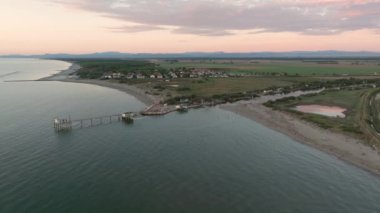 Gün batımında nehir kıyısındaki balıkçı kulübelerinin hava görüntüsü Comacchio Vadisi yakınlarındaki 
