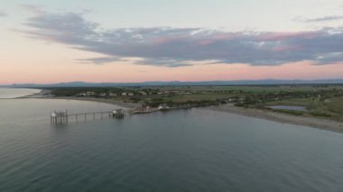 Gün batımında nehir kıyısındaki balıkçı kulübelerinin hava görüntüsü Comacchio Vadisi yakınlarındaki 