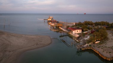 Gün batımında nehir kıyısındaki balıkçı kulübelerinin hava manzarası 