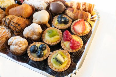 Pasta şefi tarafından yapılan lezzetli ve renkli hamur işleri. Hepsi lezzetli ve lezzetli görünüyor. Parti için mükemmel. Doğal ışık