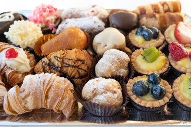 Pasta şefi tarafından yapılan lezzetli ve renkli hamur işleri. Hepsi lezzetli ve lezzetli görünüyor. Parti için mükemmel. Doğal ışık