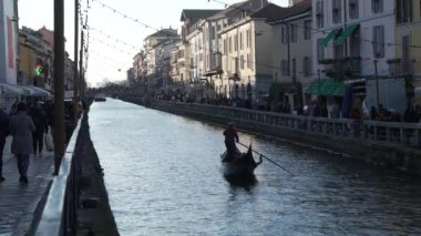 Milan,Italy-January 05,2023:People walk along the shore of the Naviglio Milanese canal and relax in the pubs,Slow-motion 30fps, Milan,Italy.