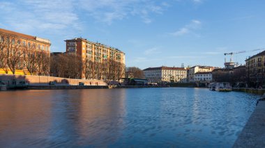 Milan,Italy-January 05,2023:People walk along the shore of the Naviglio Milanese canal and relax in the pubs,Milan,Italy.