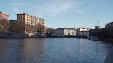 Milan,Italy-January 05,2023:People walk along the shore of the Naviglio Milanese canal and relax in the pubs,Milan,Italy.