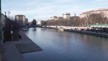 Milan,Italy-January 05,2023:People walk along the shore of the Naviglio Milanese canal and relax in the pubs,Milan,Italy.