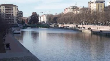 Milan,Italy-January 05,2023:People walk along the shore of the Naviglio Milanese canal and relax in the pubs,Milan,Italy.