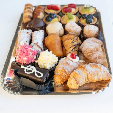 Pasta şefi tarafından yapılan lezzetli ve renkli hamur işlerinin üst düzey görüntüsü. Hepsi lezzetli ve lezzetli görünüyor. Parti için mükemmel. Doğal ışık