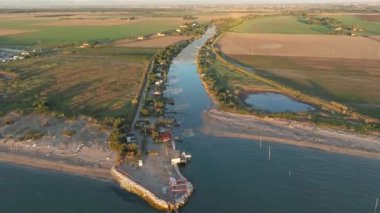 Gün batımında nehir kıyısındaki balıkçı kulübelerinin hava manzarası, 