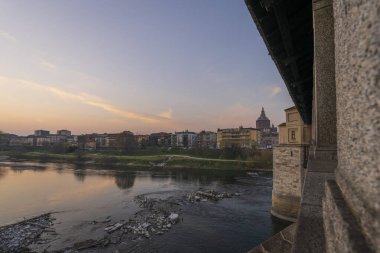 Pavia 'nın Skyline' ı, Ponte Koperto (üstü kapalı köprü), Pavia 'da gün batımında Ticino Nehri üzerinde yer alan bir köprüdür.