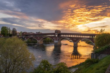 Ponte Coperto (üstü kapalı köprü) Pavia 'daki Ticino Nehri üzerinde gün batımında, Lombardy, İtalya.