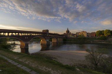 Pavia 'nın Skyline' ı, Ponte Koperto (üstü kapalı köprü), Pavia 'da gün batımında Ticino Nehri üzerinde yer alan bir köprüdür.