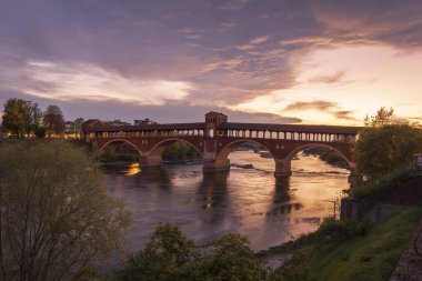 Pavia 'daki Ticino Nehri üzerindeki Ponte Koperto' nun mavi saat üzerindeki manzarası güzel, Lombardy, İtalya.