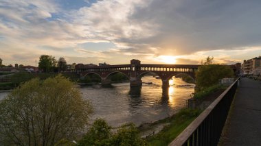 Ponte Coperto (üstü kapalı köprü) Pavia 'daki Ticino Nehri üzerinde gün batımında, Lombardy, İtalya.