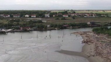 Bulutlu bir günde nehir kıyısındaki balıkçı kulübelerinin hava manzarası 