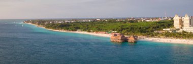 Güneşli bir günde kıyı şeridi manzarası, kumlu sahil drone manzarası, turkuaz okyanus, lüks tatil köyü ve güzel otlak stilt evi restoranı, Zanzibar, Tanzanya